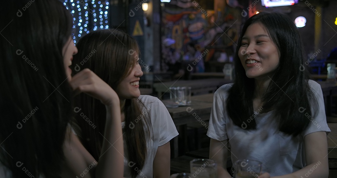 Amigos de mulheres asiáticas festejando e bebendo álcool