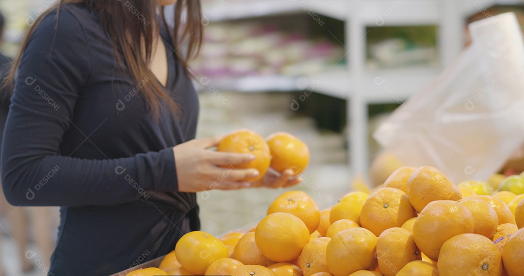 Compra de uma jovem escolhe frutas frescas