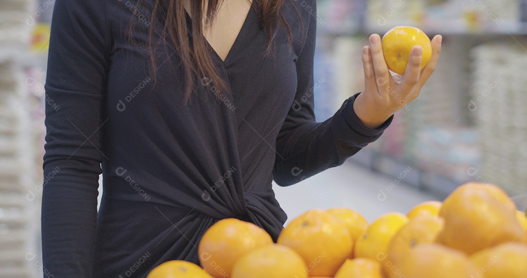 Compra de uma jovem escolhe frutas frescas