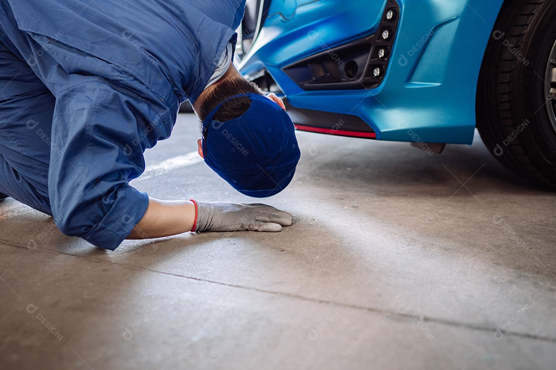 Homem mecânico examinando e fazendo manutenção no carro