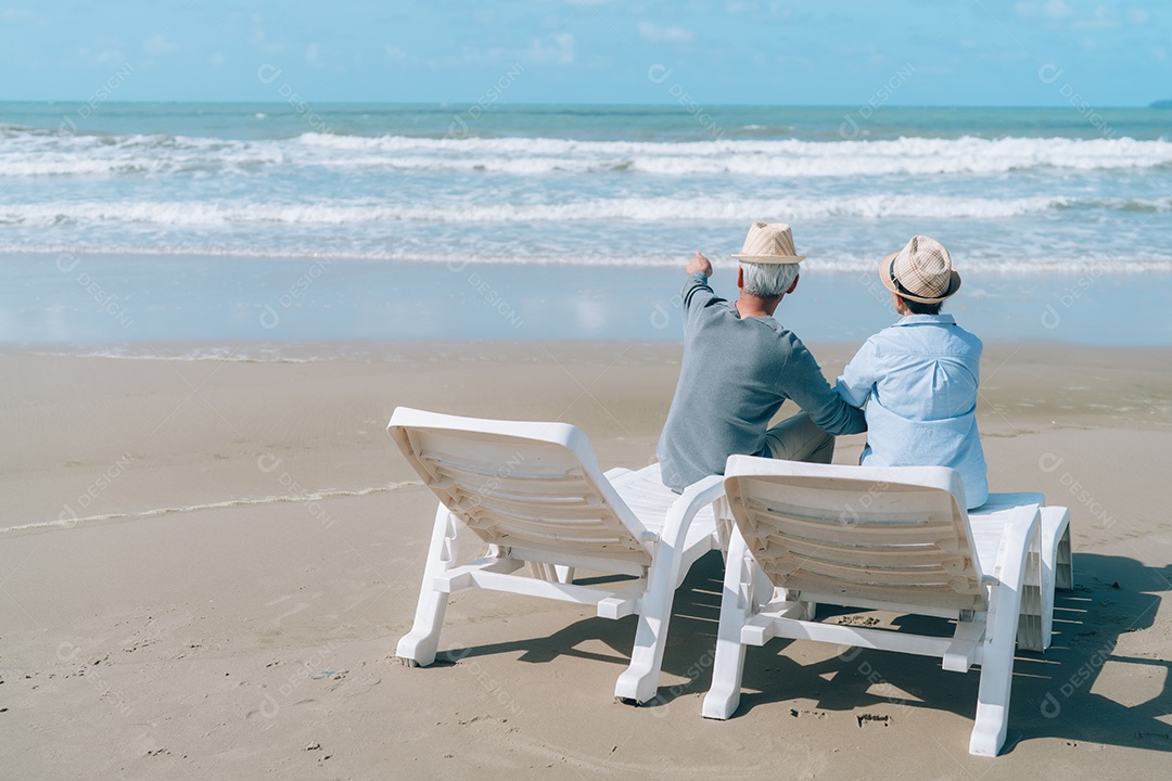 Feliz casal asiático de idosos descansando na praia