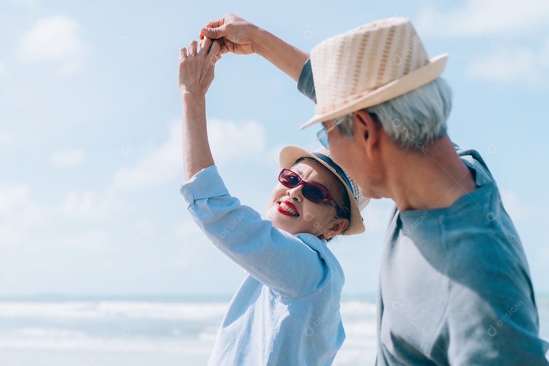 Feliz casal asiático de idosos descansando na praia