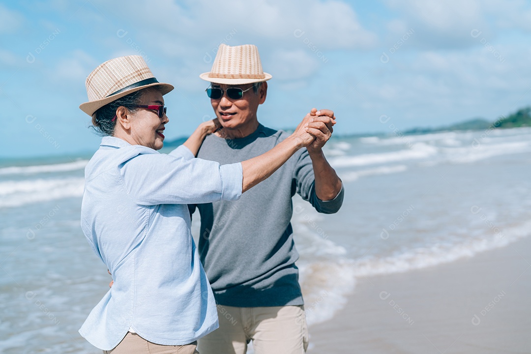 Feliz casal asiático de idosos descansando na praia