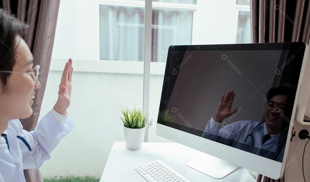 Jovem médico asiático em consultório usando computador portátil