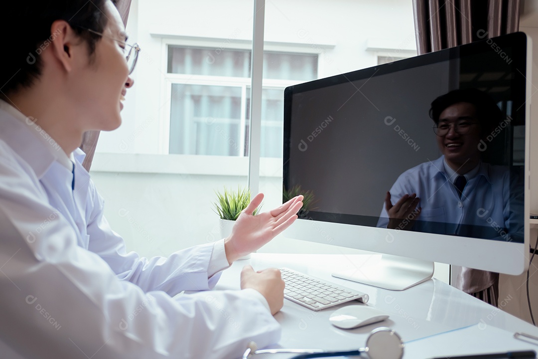 Jovem médico asiático em consultório usando computador portátil