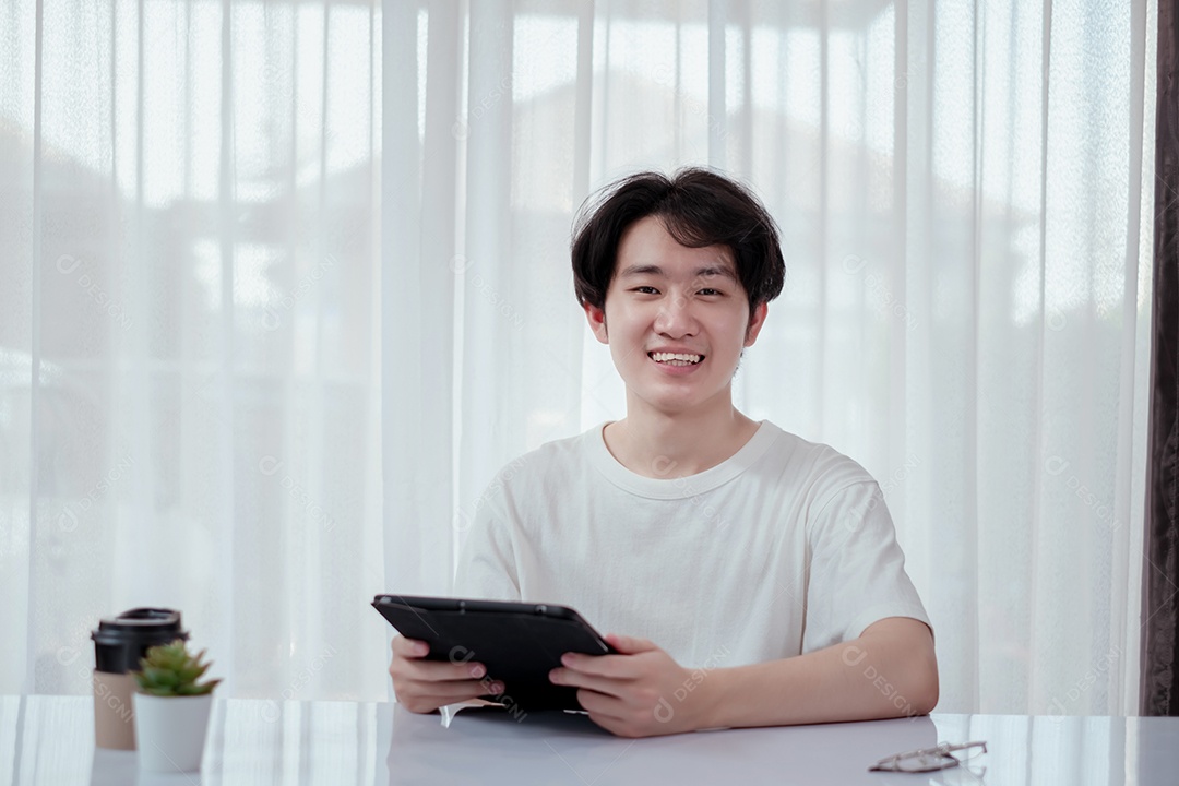 Jovem asiático sorridente usando tablet digital