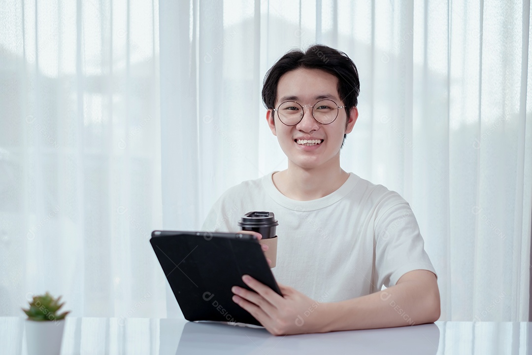 Jovem asiático sorridente usando tablet digital