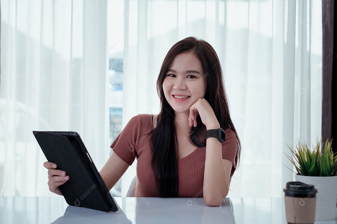 Jovem asiática sorridente usando tablet digital