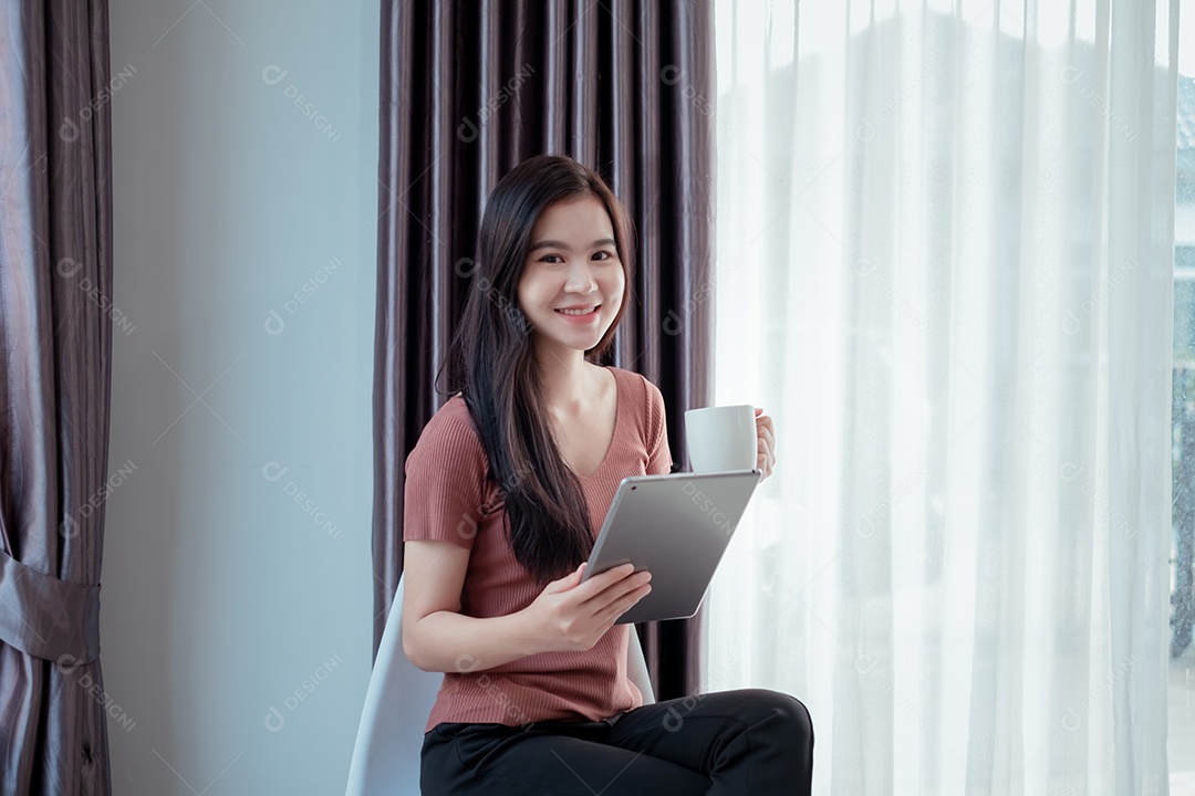 Jovem asiática sorridente usando tablet digital