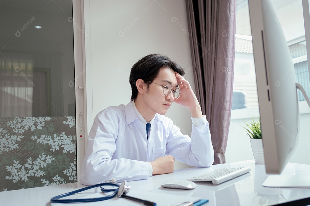 Médico masculino trabalhando com computador na clínica