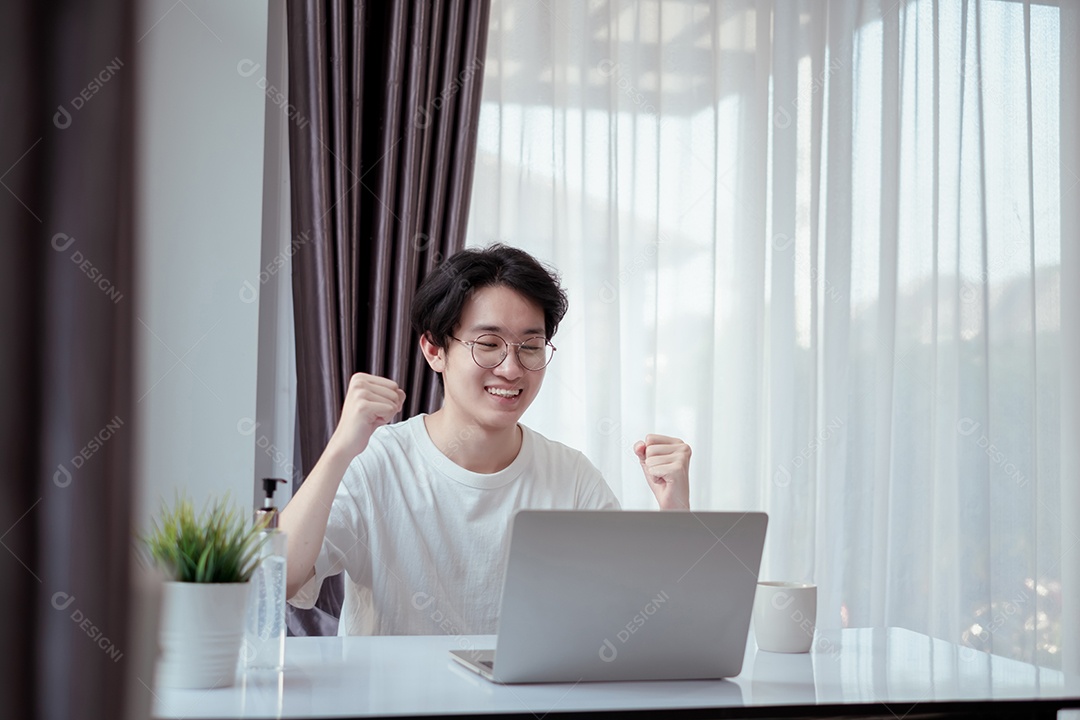 Homem asiático trabalhando em casa com computador portátil auto-isolado
