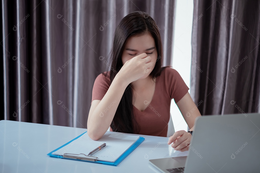 A mulher asiática que trabalha em home office