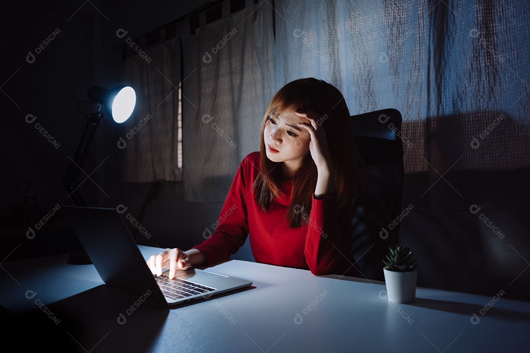 Mulher asiática trabalhando tarde da noite com laptop em casa