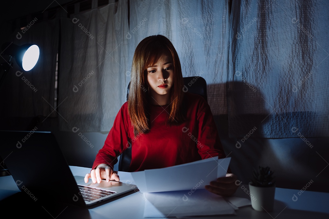 Mulher asiática trabalhando tarde da noite com laptop em casa