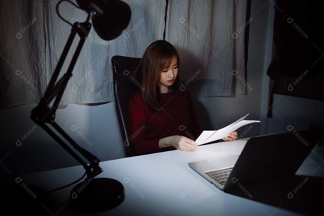 Mulher asiática trabalhando tarde da noite com laptop em casa