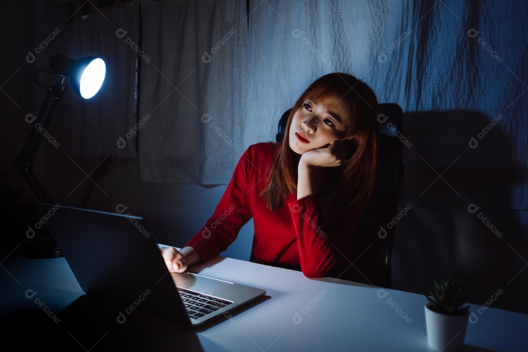 Mulher asiática trabalhando tarde da noite com laptop em casa