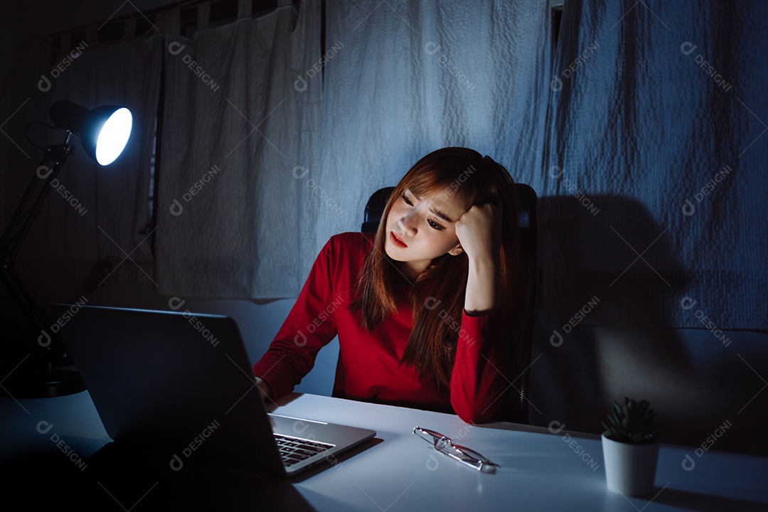 Mulher asiática trabalhando tarde da noite com laptop em casa