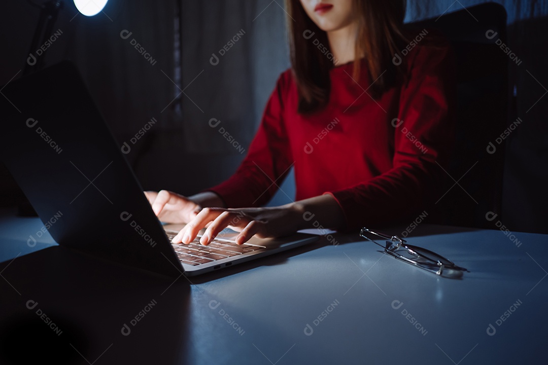 Mulher asiática trabalhando tarde da noite com laptop em casa