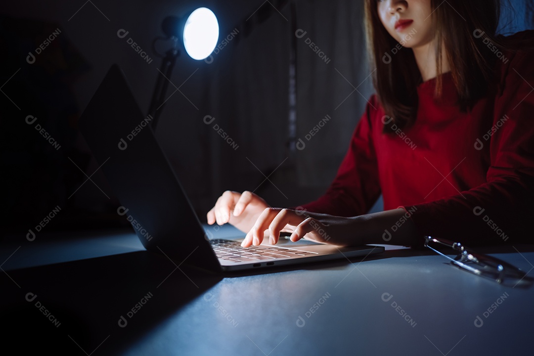Mulher asiática trabalhando tarde da noite com laptop em casa