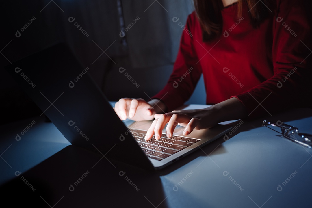 Mulher asiática trabalhando tarde da noite com laptop em casa