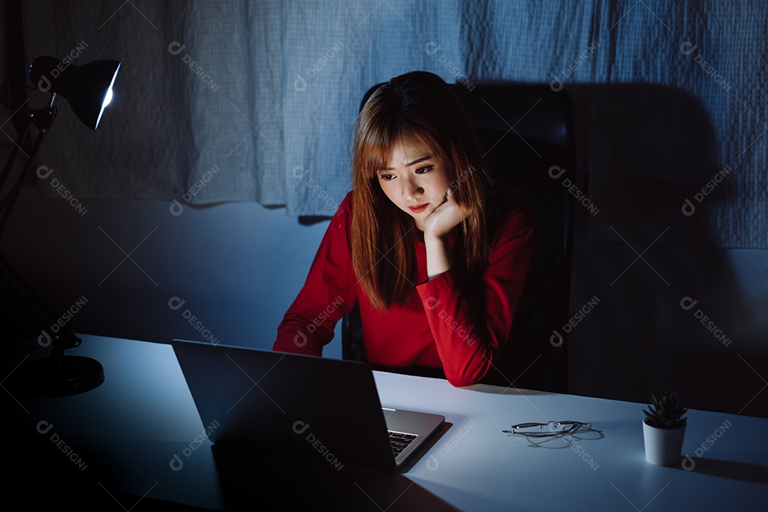 Mulher asiática trabalhando tarde da noite com laptop em casa