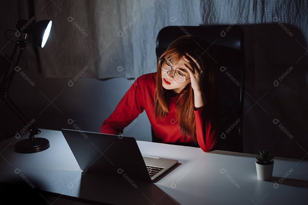 Mulher asiática trabalhando tarde da noite com laptop em casa
