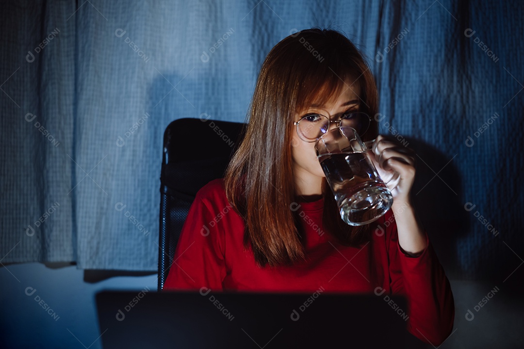 Mulher asiática trabalhando tarde da noite com laptop em casa