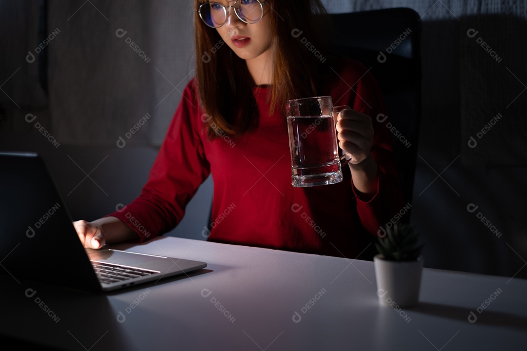 Mulher asiática trabalhando tarde da noite com laptop em casa