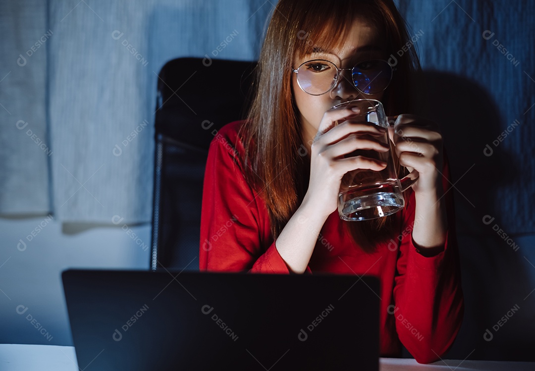 Mulher asiática trabalhando tarde da noite com laptop em casa