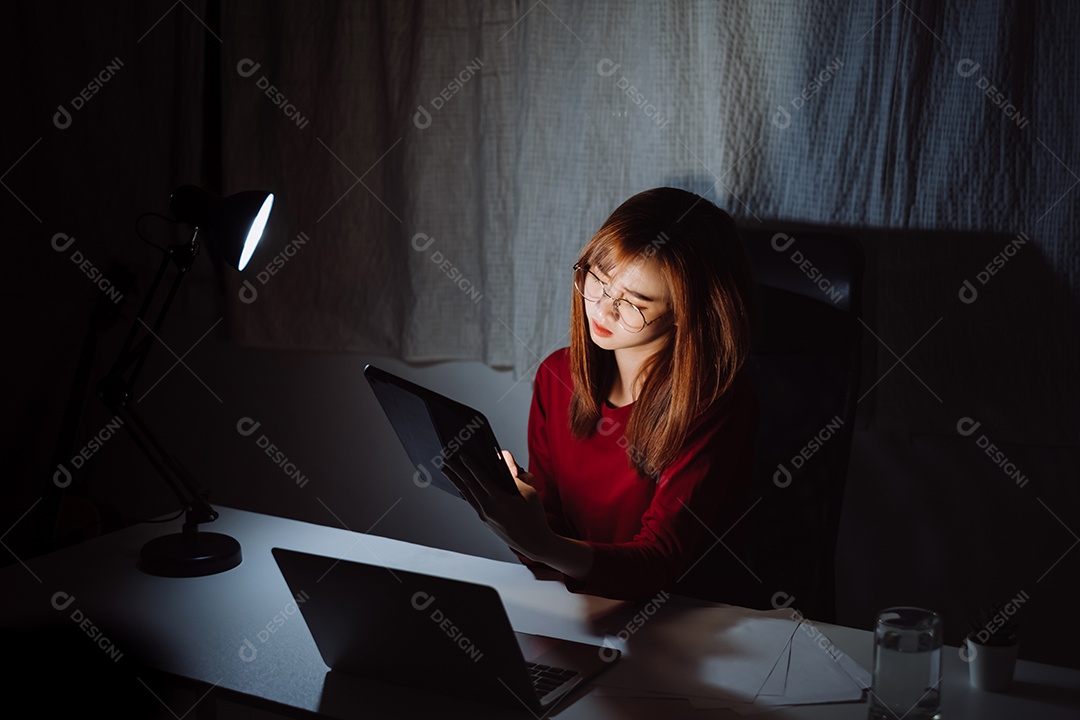 Mulher asiática trabalhando até tarde da noite