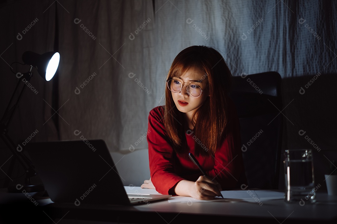 Mulher asiática trabalhando até tarde da noite