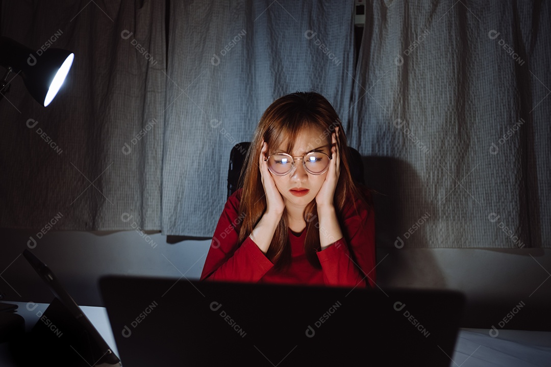Mulher asiática trabalhando tarde da noite com laptop em casa