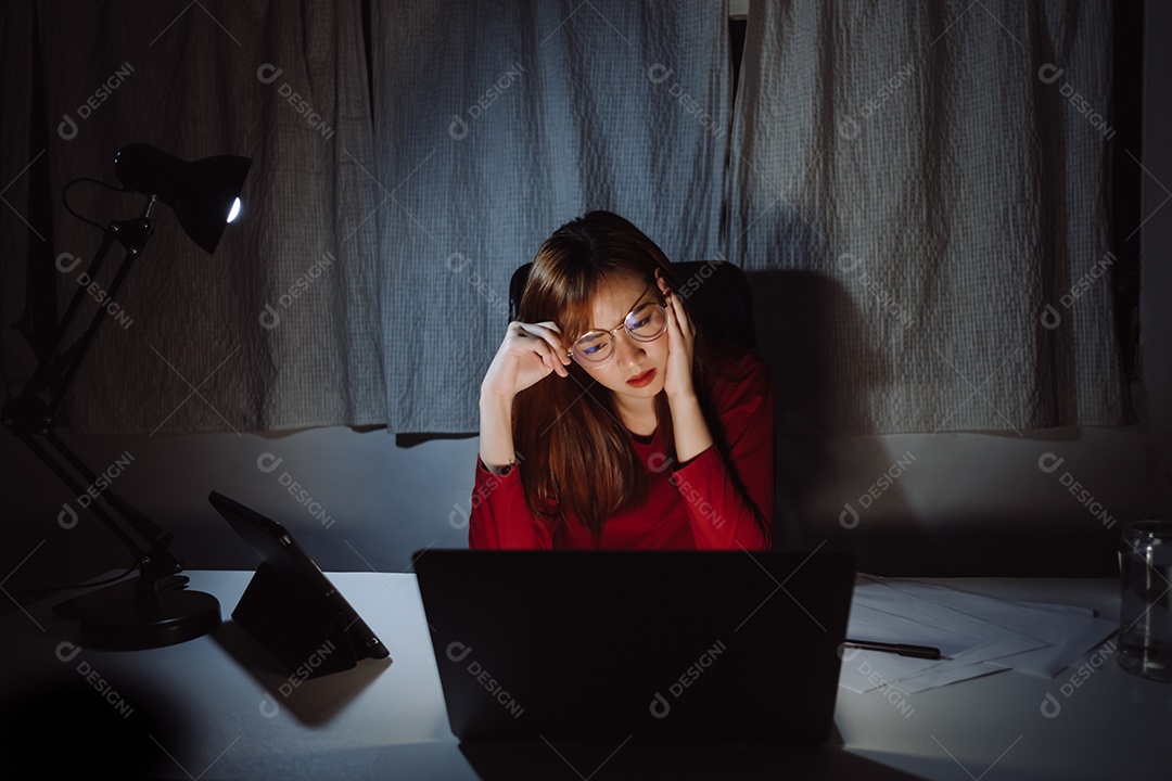 Mulher asiática trabalhando tarde da noite com laptop em casa