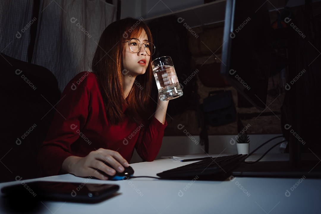 Mulher coreana trabalhando até tarde com computador