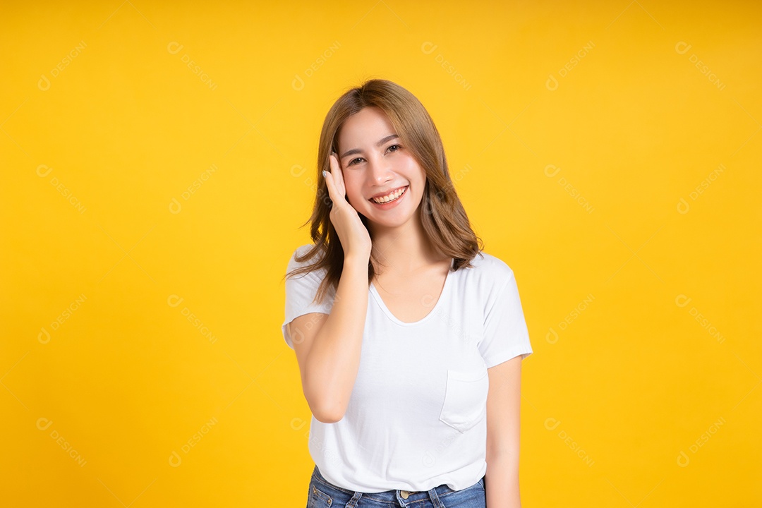 Retrato feliz jovem mulher asiática sorrindo segurando a orelha ouvindo algo