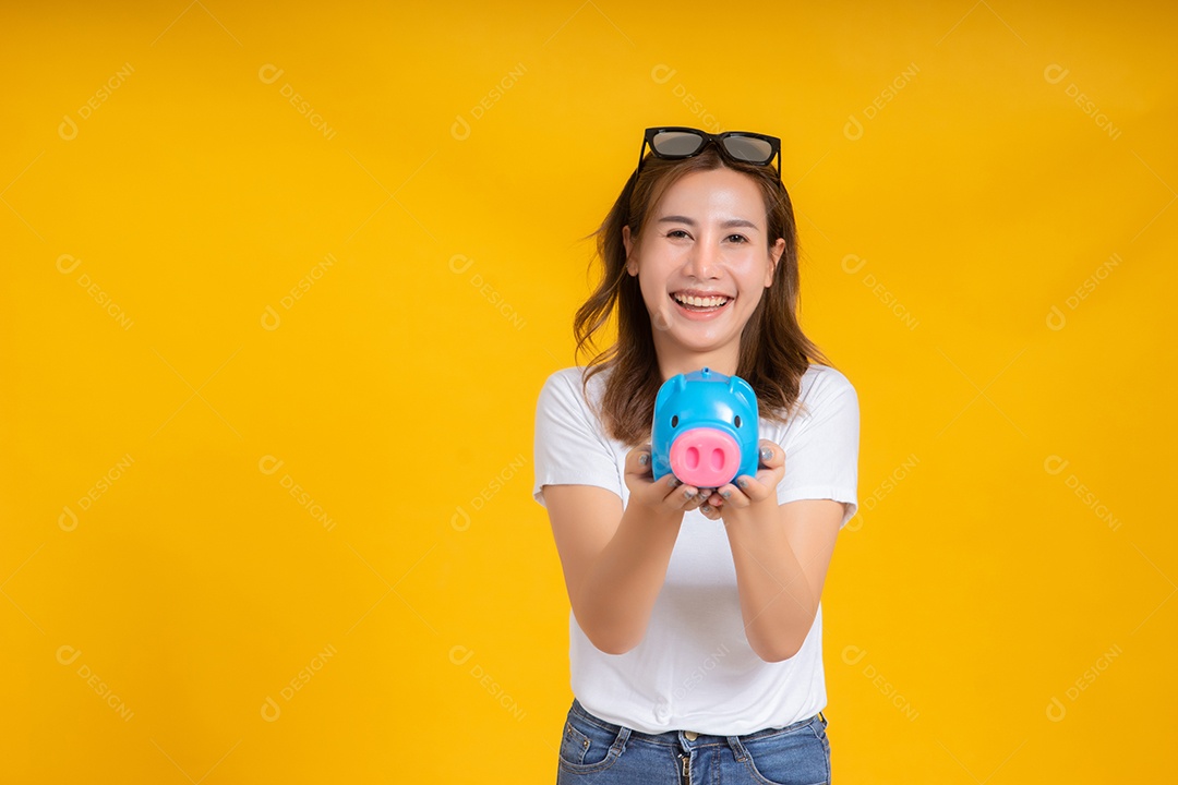 Retrato feliz jovem mulher asiática segurando cofrinho economizando dinheiro para futuro