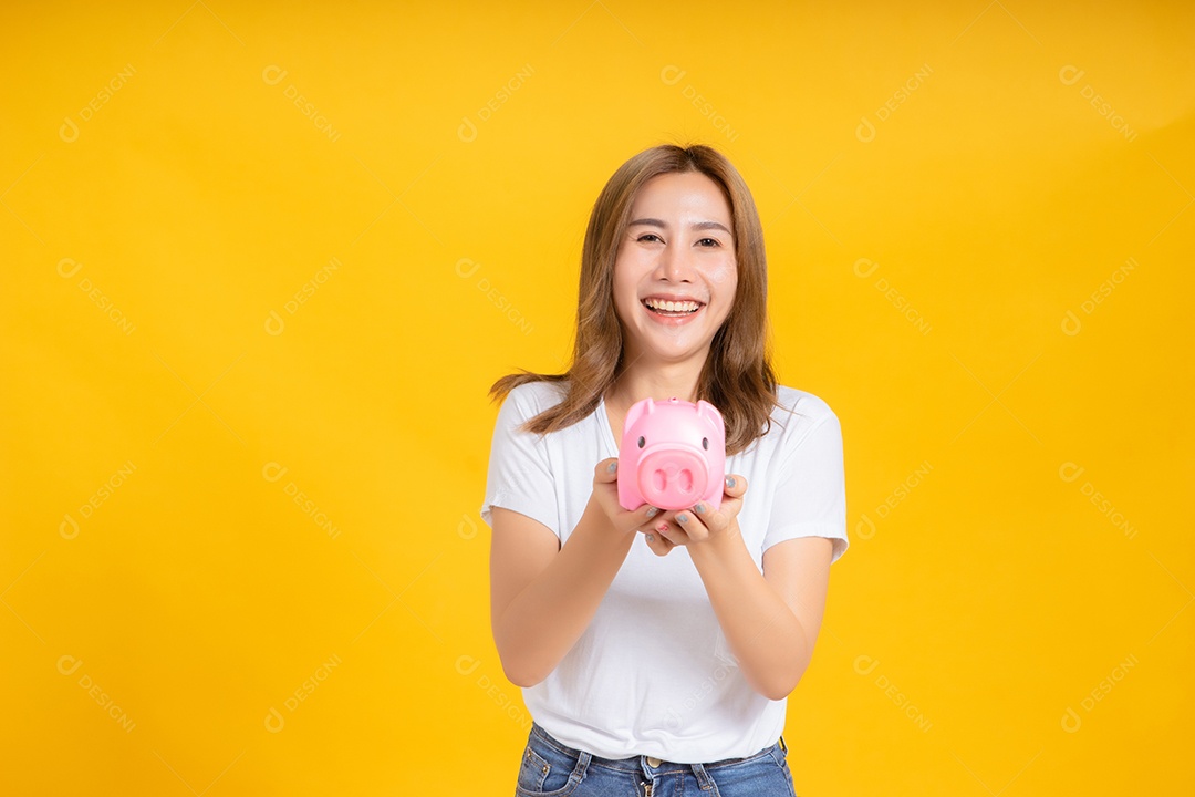 Retrato feliz jovem mulher asiática segurando cofrinho economizando dinheiro para futuro
