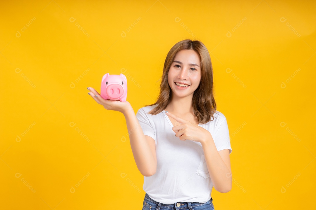 Retrato feliz jovem mulher asiática segurando cofrinho economizando dinheiro para futuro