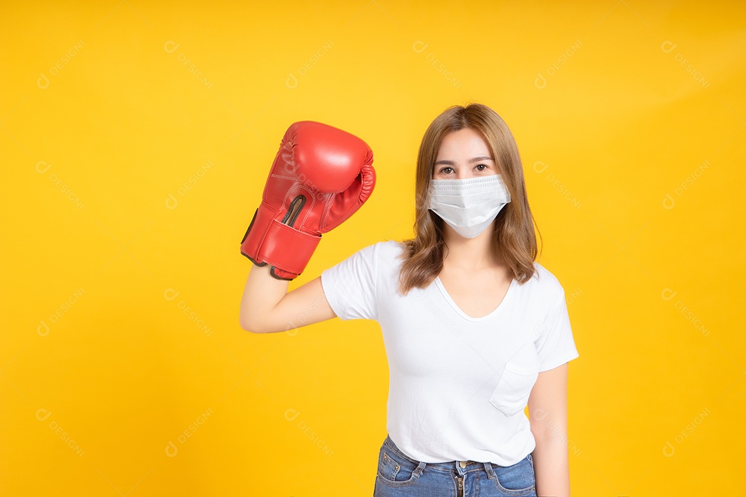 Jovem mulher asiática com proteção de máscara médica coronavírus COVID-19 lutando usando luvas de boxe conceito de cuidados