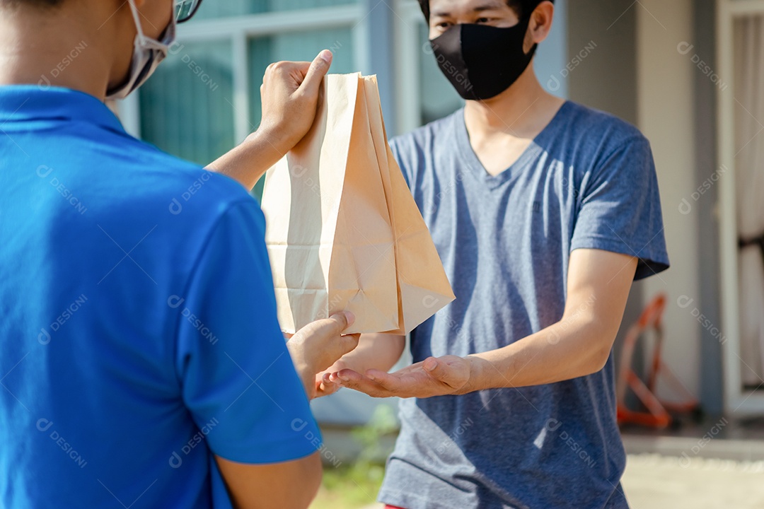 Entregador asiático usando máscara entrega comida na pandemia