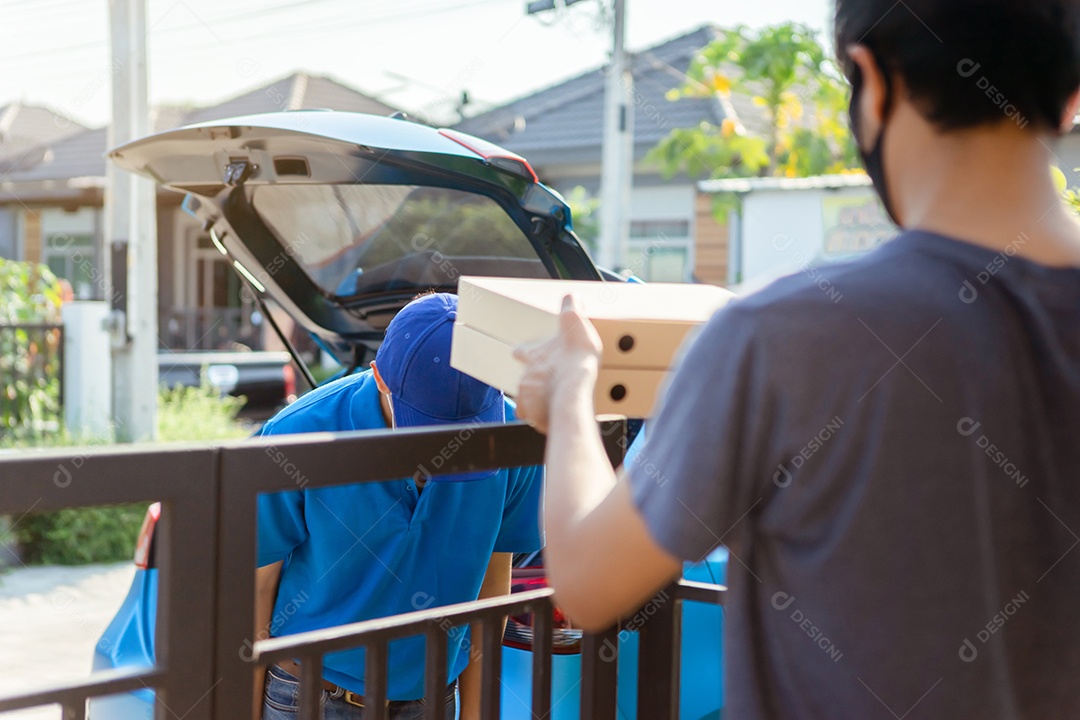 O entregador asiático usando máscara envia pizza na pandemia