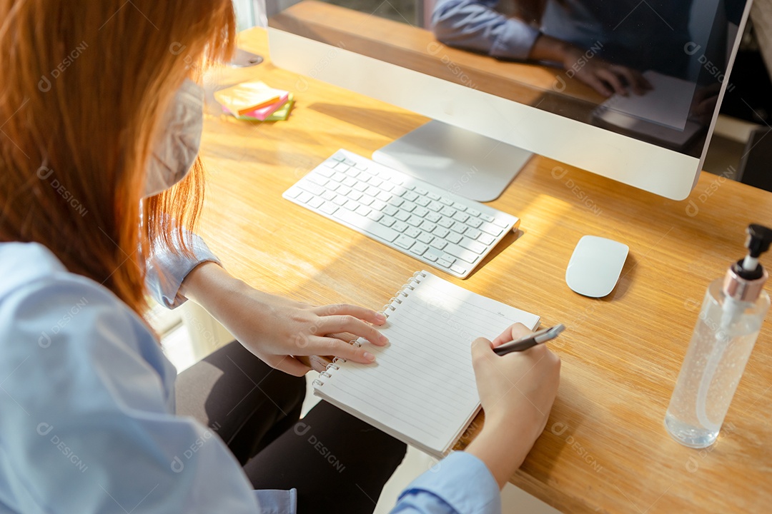 Mulher asiática usando máscara trabalhando em casa