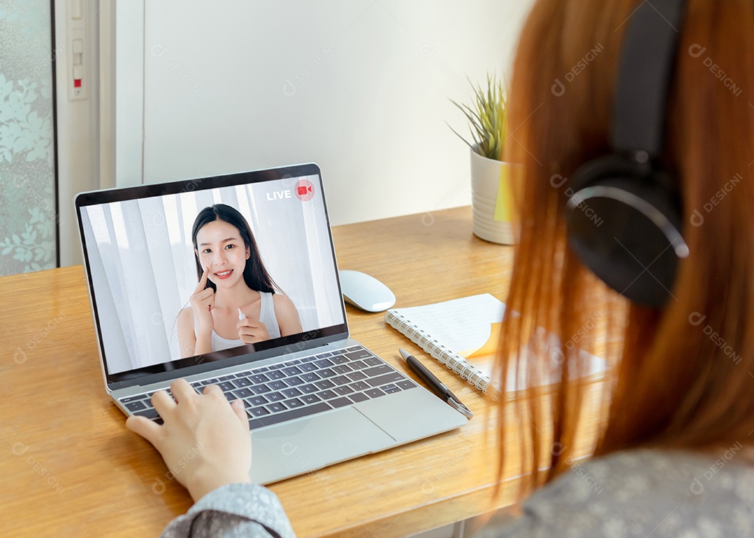 Vista traseira tiro jovem mulher asiática assistindo vídeo ao vivo streaming de beleza