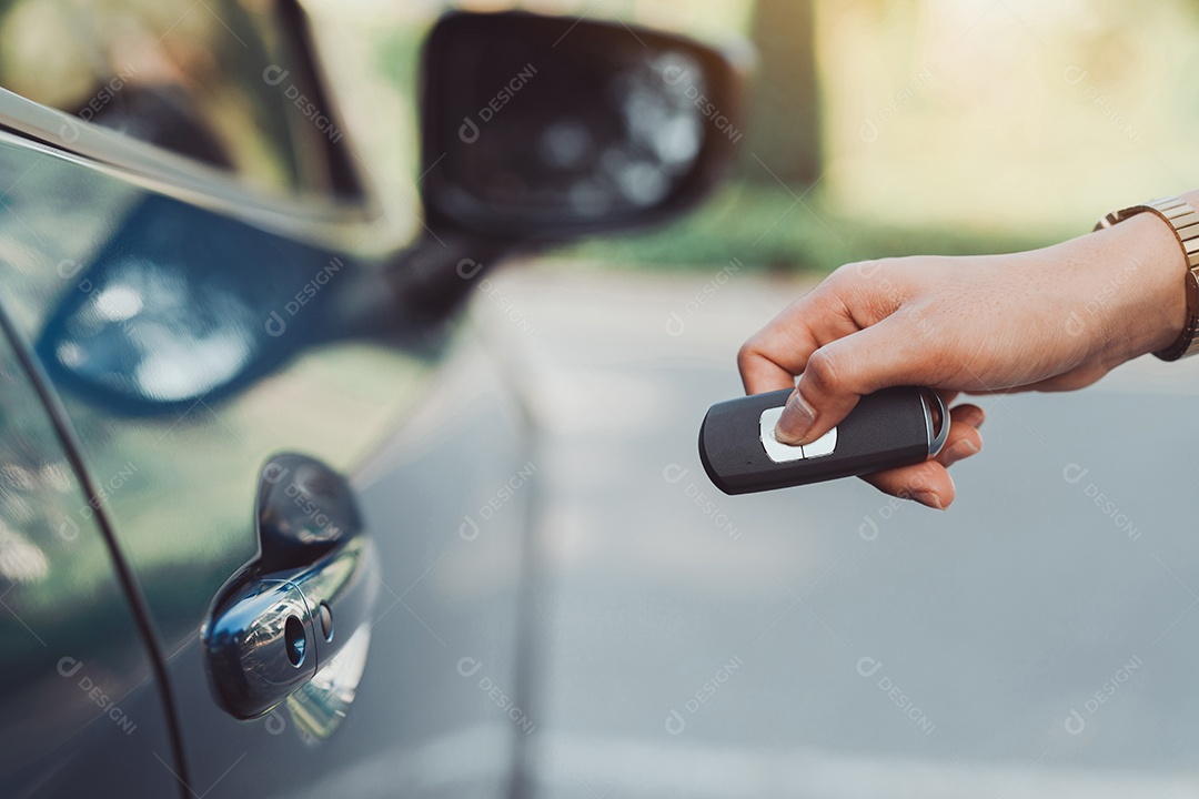 Mãos da mulher pressionando controle da chave do carro