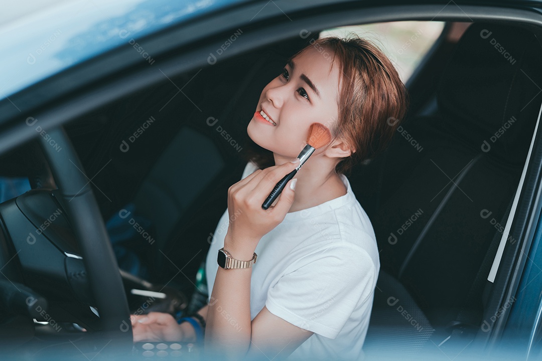 Belas mulheres asiáticas aplicando maquiagem no interior do carro