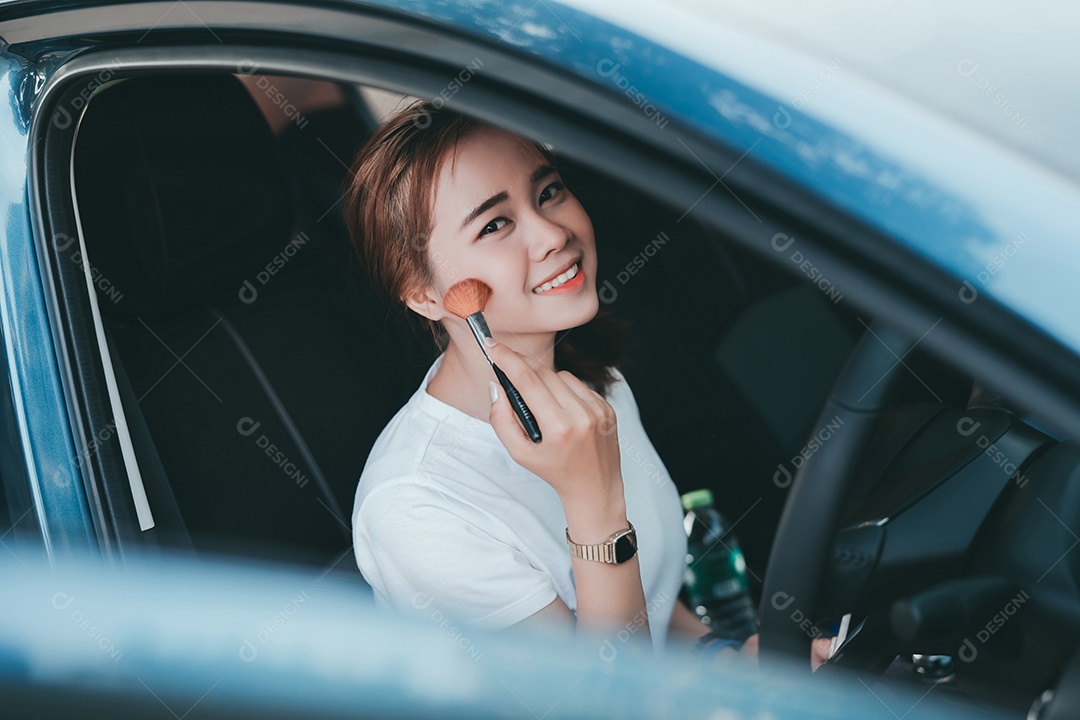 Belas mulheres asiáticas aplicando maquiagem no interior do carro
