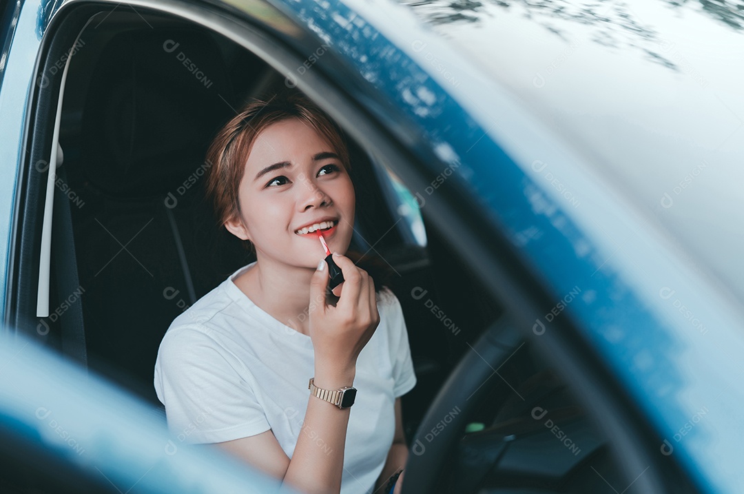 Belas mulheres asiáticas aplicando maquiagem no interior do carro