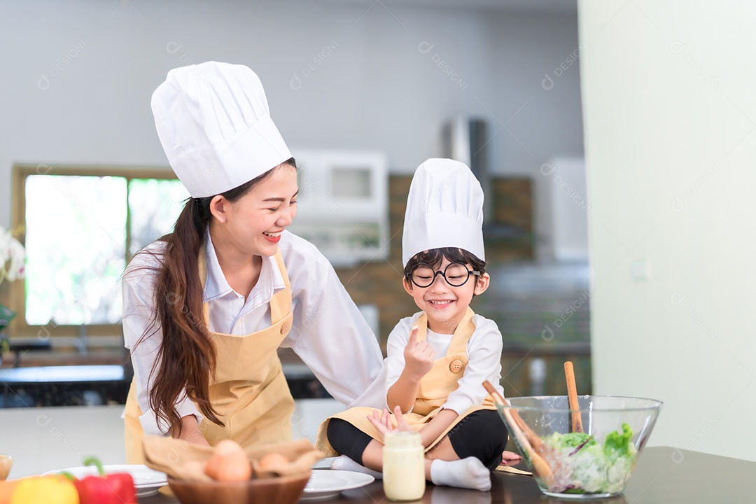Chef profissional mãe asiática ensinando menu de lista de filho pequeno cozinhando vegetais