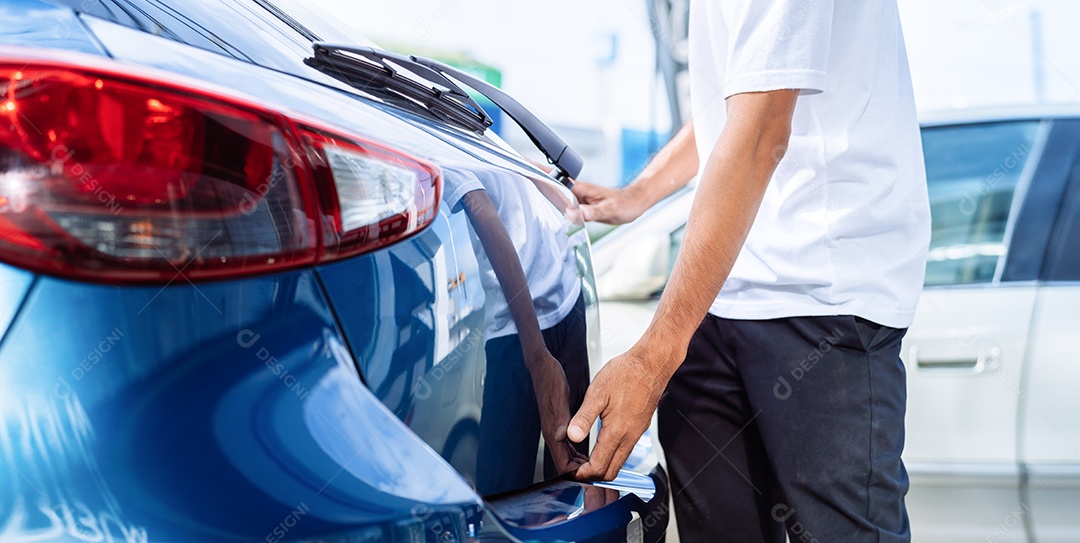 Homem abrindo porta mala de carro