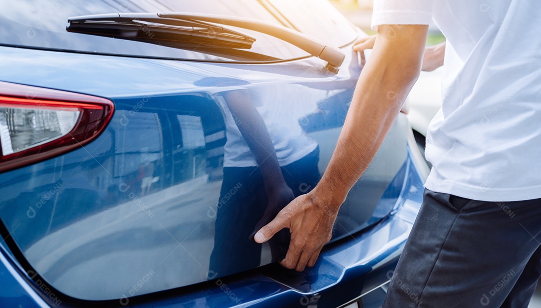 Homem abrindo porta mala de carro